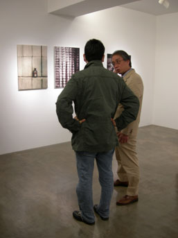 Next door at Miyake Fine Arts, Director Shinichi Miyake (right) talks to a guest about the Florian Süssmayr exhibition they are currently holding.