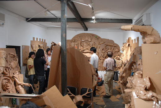 The gallery is filled with the detritus of cardboard sculptures and reliefs...