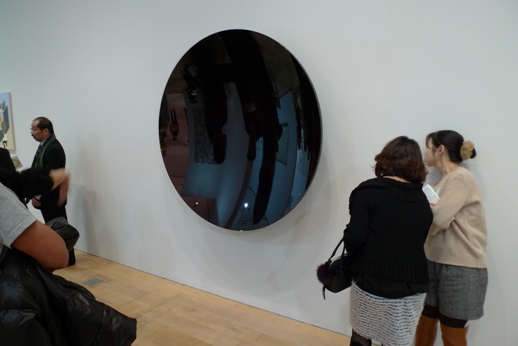 Visitors peer at a work by Anish Kapoor, opposite the SCAI The Bathhouse booth.
