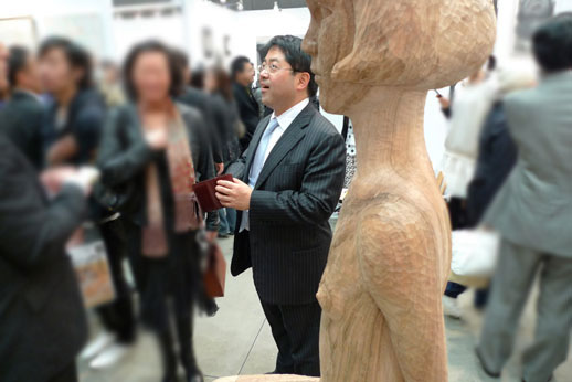 Tomio Koyama hard at work meeting and greeting all the visitors. The large sculpture 'girl' (2009) by Rieko Otake is in the foreground.