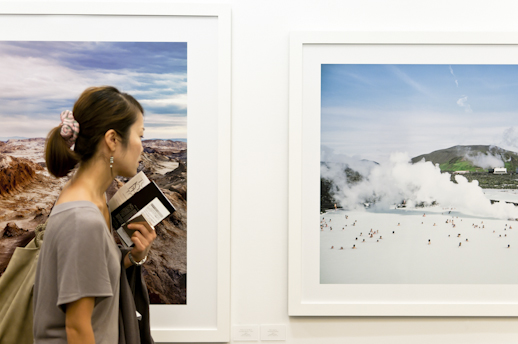 A girl looks at landscape photos from Marunouchi Gallery.
