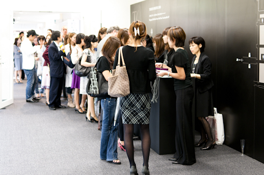 People lining up at the reception desk.