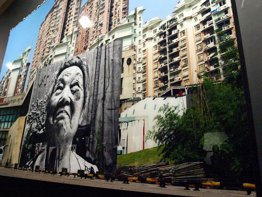 JR, a prolific street artist, is known for wheat-pasting his building size portraits in cities around the world.
