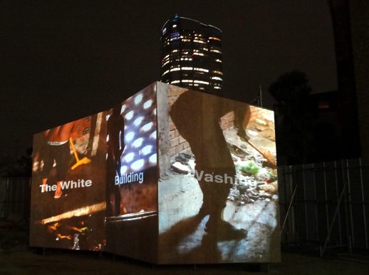 Under an increasingly bleak sky, people converged to a vacant lot to watch Masaru Iwai's 'The white building washing'.