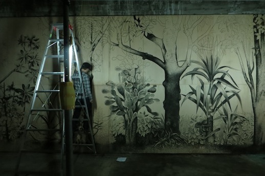 Naoki Sato at work on 'Soko de Haiteiru' (2013) Charcoal on plywood panels