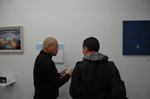 Gallery owner Mori Yuichi talking to editor Tetsuya Ozaki in front of the works.
