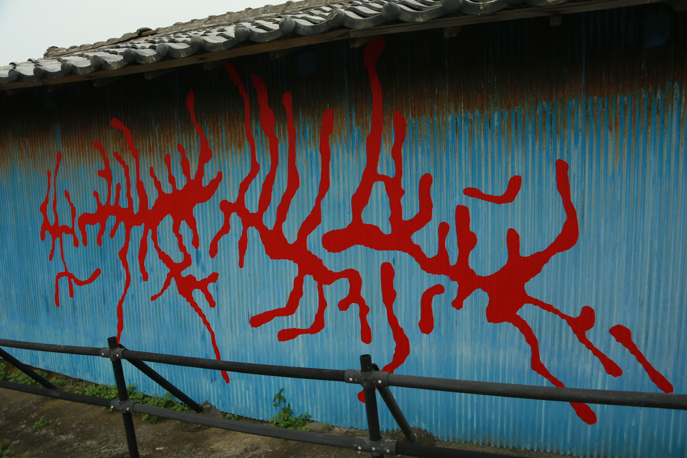 昆虫の這った跡を描いたペインティング。独特な赤色の絵の具を用いて製作されている