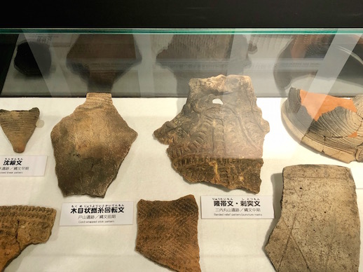 Fragments of Jomon pottery at the Komakino Site Preservation Museum showing different decorative patterns