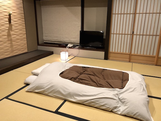 A room at Sumiya Kiho-an. The inn is in the traditional Japanese style with tatami, sliding shoji doors, and a futon.